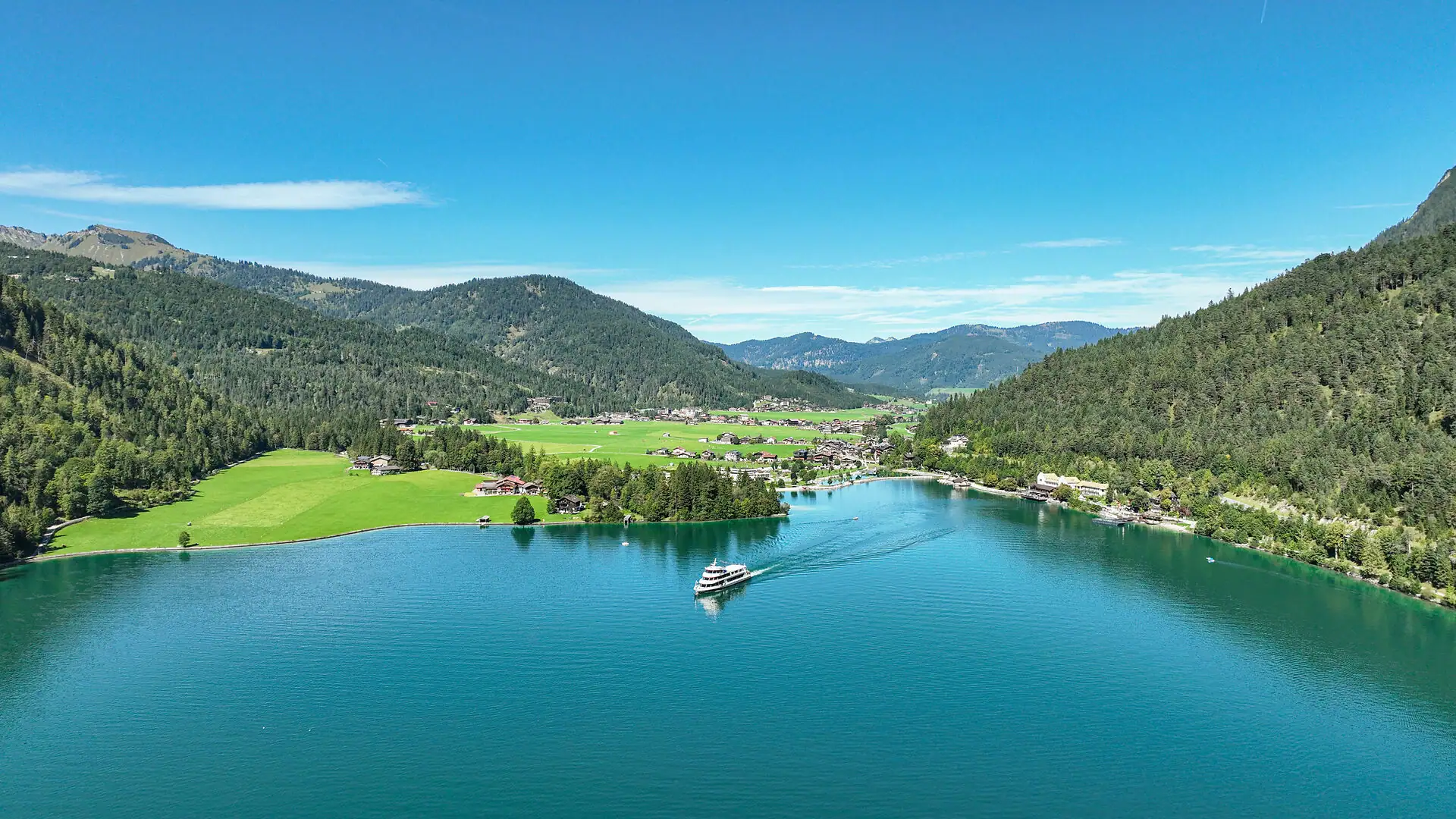 Blick auf den Achensee mit Boot und umliegenden Bergen in Tirol.